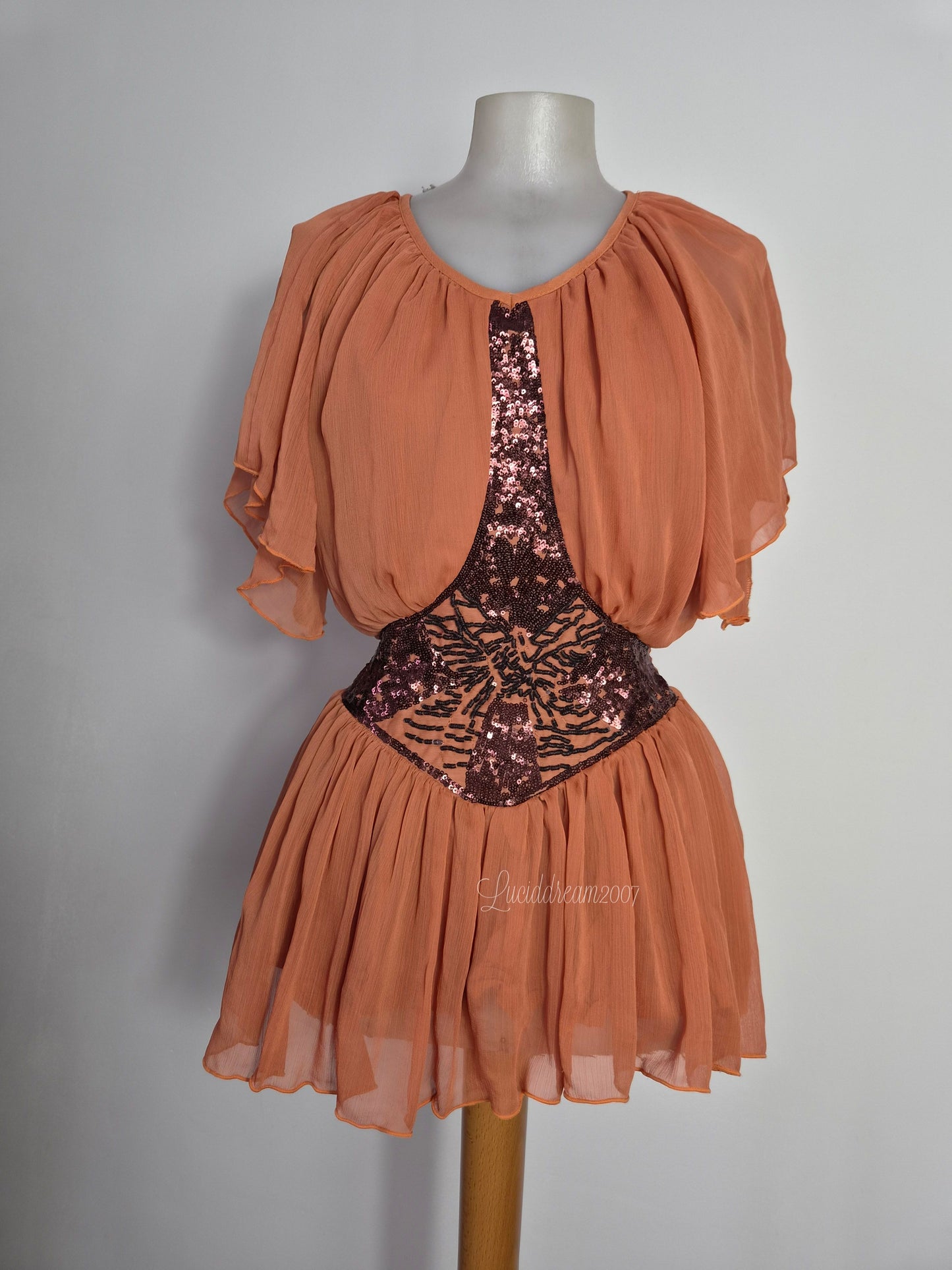 Chemisier vintage bohème chic en mousseline pêche avec des détails complexes de sequins et de perles sur le corsage. Style fairycore romantique et fluide. sorti d'une reverie vintage